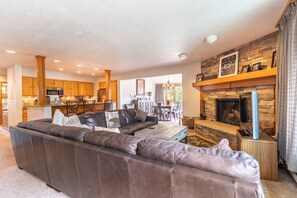 Living area featuring flat screen TV, large sectional, wood-burning fireplace and access to the private balcony.