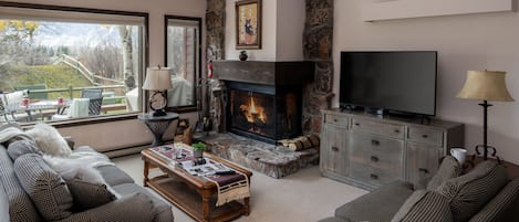 Cozy living room with Teton range views, a wood burning fireplace and a queen sleeper sofa