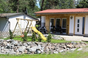 Großer Garten mit überdachter Terrasse und Kinderspielplatz