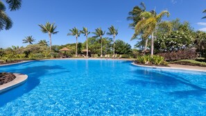 Relaxing Kamilo community pool surrounded by lush gardens, Just a short walk from the home
