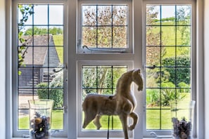 Sitting room window overlooking the front gardens and barns with fields beyond.