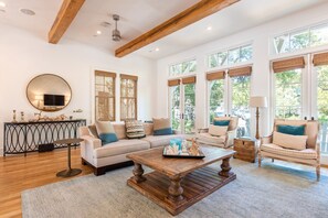 Arm Chairs, Sofa, Coffee Table, Ceiling Fan, and Window Doors.