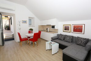 Living area with sofa, satellite TV,  A/C. opening onto the large terrace.