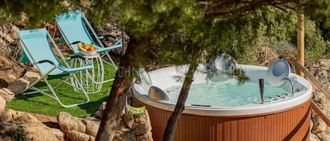 Villa for rent in northern Sardinia with outdoor Jacuzzi, surrounded by greenery.