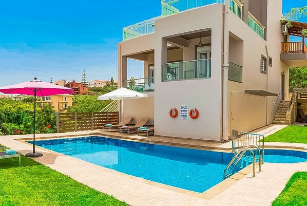 Outside area with private pool and sunbeds.