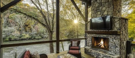 Covered Deck with fireplace over looking Toccoa River