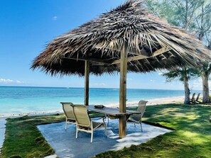 Enjoy outdoor dining under our thatch, beach front dining area.