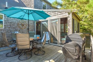 back deck with table, chairs, umbrella and grill