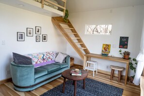 Brand new room with vintage sofa, bright sunlight, back yard view, and desk