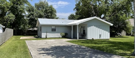 front view of house, driveway, and side privacy fence from the street