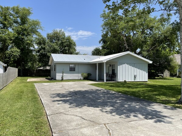 front view of house, driveway, and side privacy fence from the street