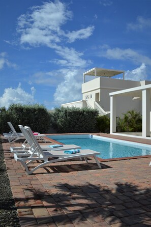 Spacious backyard with pool and beach chairs 