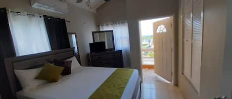 Front bedroom with private bathroom,  air conditioning unit, ceiling fan, smart TV and balcony with water view