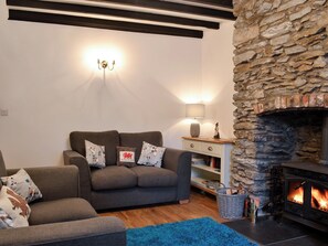 Beamed living room with exposed stone chimney breast | Noddfa Cottage, Llanfairtalhaiarn, near Abergele