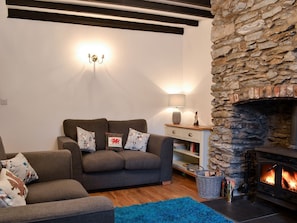 Beamed living room with exposed stone chimney breast | Noddfa Cottage, Llanfairtalhaiarn, near Abergele