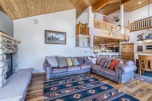 Living Area - Large couch, flat screen TV, large windows, and gas fireplace.