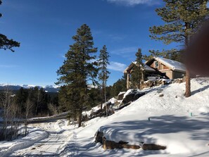 A cabin on a snowy hillside.