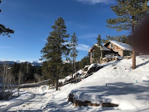 A cabin on a snowy hillside.