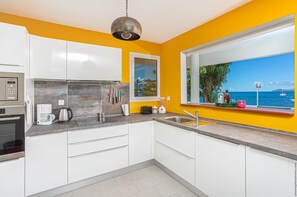 The fully equipped kitchen, which is open to the sea, is ideal for entertaining family and friends.
