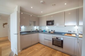 Harbour Lights in Lusty Glaze, Newquay: Kitchen with modern units and Bosch appliances including an oven and hob, microwave, dishwasher and fridge/freezer