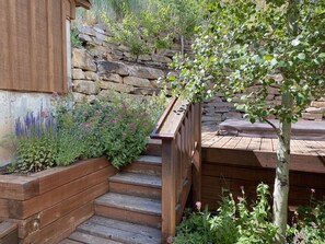 private back patio with steps up to hot tub