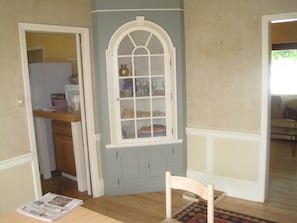 Lovely corner cabinet in dining room, with vases, platters, wine glasses inside.