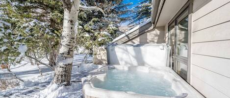 Relax on the back deck of the home in this large private hot tub with mountain views of the slopes at Deer Valley.
