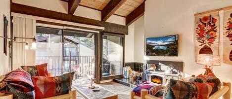 Cozy living room w/ Smart TV, wood burning fireplace, balcony access