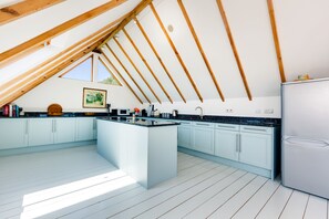 Dolphins, Coverack. First floor: Open-plan kitchen with granite tops, central island, double oven and hob, fridge/freezer and dishwasher