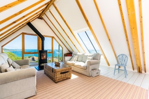 Dolphins, Coverack. First floor: Sitting room with a contemporary wood burning stove and sea views