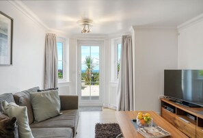 Blue Horizon, Carbis Bay: Sitting room with sea and coastal views, television and a door to the front patio.