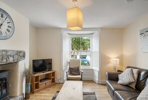 The Boy's Cottage, Portreath. Ground floor: Sitting room with feature fireplace, electric stove and television