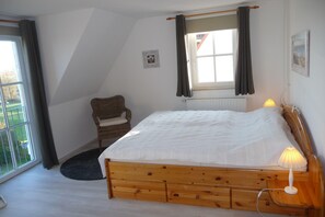 1. Schlafzimmer im Obergeschoß mit Doppelbett, Kleiderschrank und Leseecke.