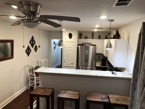 Kitchen area has a bistro dining set as well as 4 large barstools