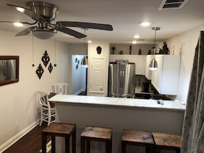 Kitchen area has a bistro dining set as well as 4 large barstools