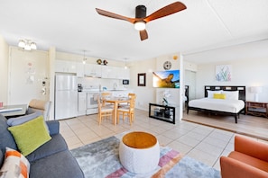 Living room with pull-out sleeper sofa, smart TV, a fan, a coffee table, and a comfortable chair.