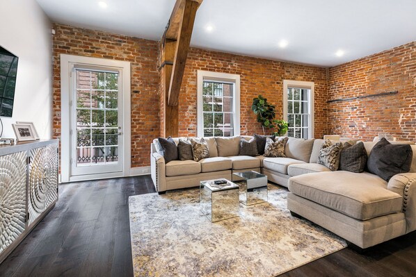 Open concept living, kitchen, and dining area with ample seating. Stream on 65” Samsung Smart 4K TV with DIRECTV. Relax on the large sectional and dine at a table for six with bar seating for four and plenty of natural light.