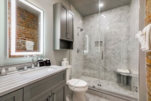 Ensuite Master Bathroom with a frameless glass Italian marble shower. Enjoy plush white towels, a blow dryer, and complimentary travel-size shampoo, conditioner, body wash, toothbrushes (2), toothpaste, and mouthwash.