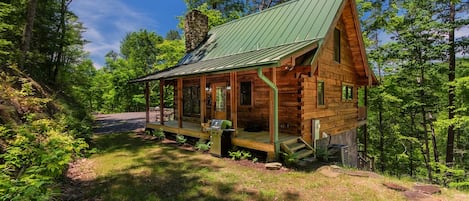 This newly built log cabin is a modern take on a classic Appalachian mountain cabin architectural design, with hand built stacked stone fireplace and rough planed log walls.