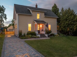 The brick paver driveway features an old fashioned block-M. 