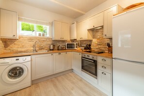 Porthgwidden Cottage, Lelant. Ground floor: Kitchen with oven, hob, dishwasher, washing machine, microwave and fridge/freezer