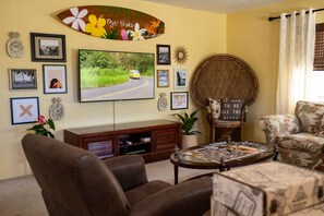 The living room features a custom, hand-painted surfboard!