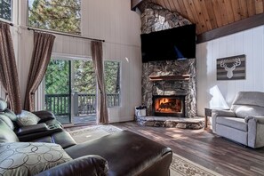 Cozy living Room with high ceilings, reclining sofa and a 70” TV 