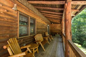 Sit a spell and take a load off on the covered front porch with log furniture.