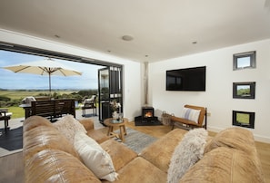 Stargazy, St Agnes. Sitting area with Smart television, wood-burning stove and bi-fold doors