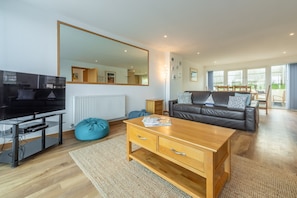 Harbour Lights, Newquay. Upper ground floor: Open plan sitting room with television and doors onto terrace.