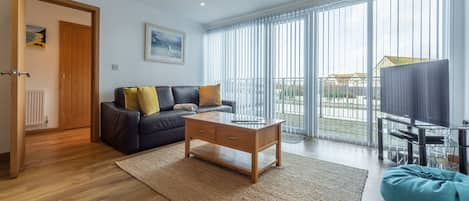 Headland Beaches, Newquay. Upper ground floor: Open plan sitting room with television and doors onto terrace.