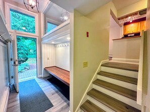 Mudroom is on a half level and has stairs up to the kitchen, dining and living areas above, and down to the lower bedrooms