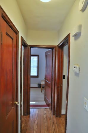 Hallway leading to separate bedrooms and separate bathroom.