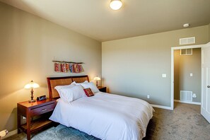 Spacious master bedroom with leather armchair and smart TV
